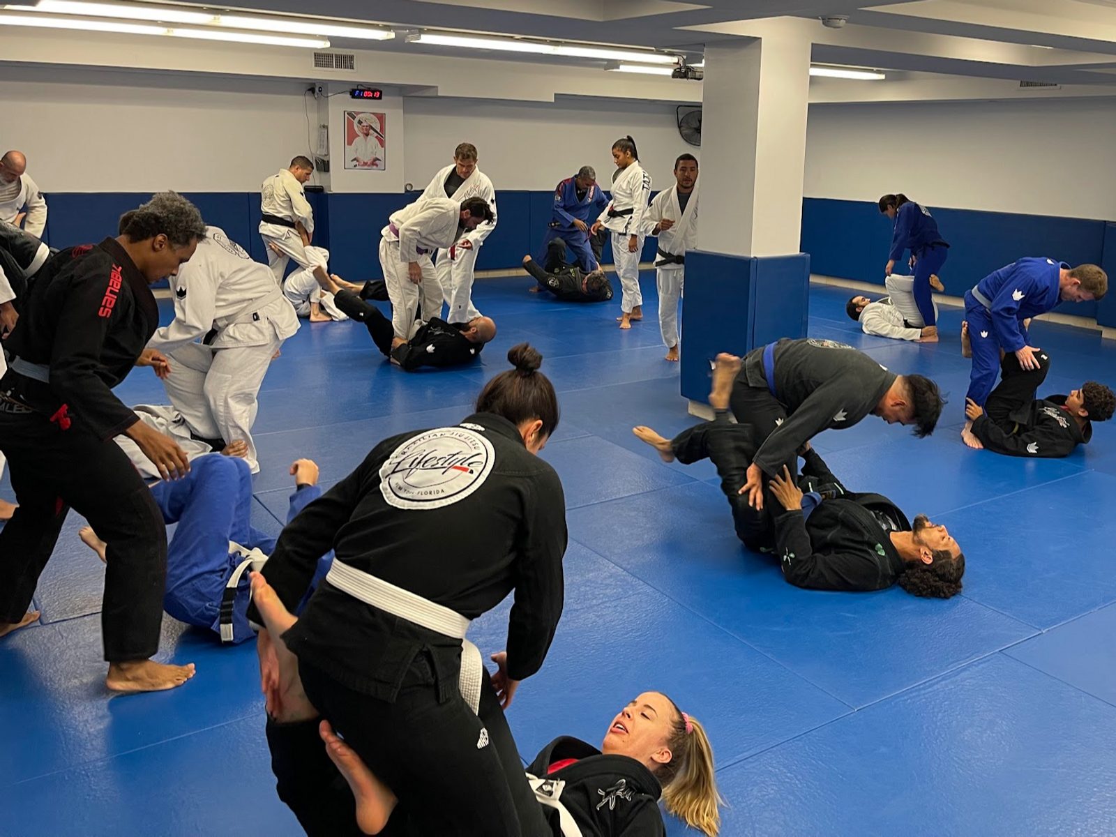Adult Brazilian Jiu-Jitsu class training on blue mats at Lifestyle BJJ in Astoria
